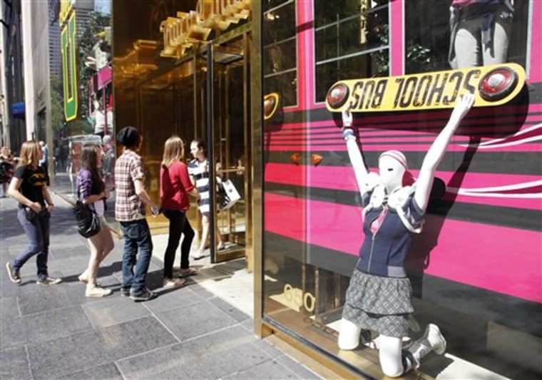 Teenagers enter a Juicy Couture clothing store that features a window display with back-to-school fashion, in New York. 